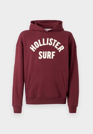 Bordinės spalvos džemperis su gaubtu ir priekiu kišene, puoštas baltu išsiuvinėtu užrašu „HOLLISTER SURF“ puslankio formos dizainu. Medvilnės mišinio medžiaga.