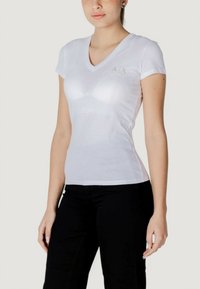 T-shirt bianco in cotone con scollo a V e maniche corte. Presenta un logo verde discreto sul petto sinistro. Design aderente che esalta la silhouette.