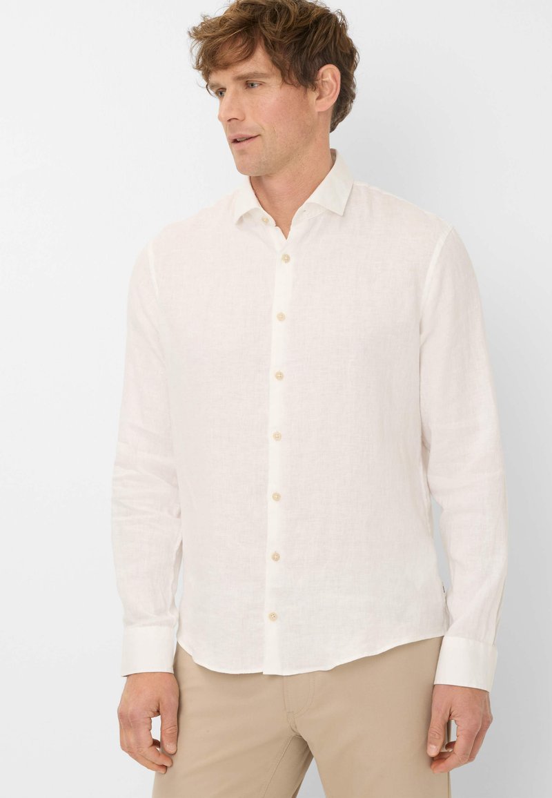 Lichtbeige linnen shirt met een klassieke kraag, knopen aan de voorkant en lange mouwen; heeft een gladde textuur en een relaxte pasvorm.