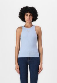 Hellblau gerippte Tanktop mit rundem Halsausschnitt und zarten Verzierungen auf der Vorderseite, kombiniert mit dunklen Jeans.