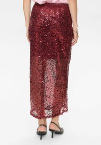 Gonna maxi in paillettes bordeaux con sovrapposizione trasparente, dotata di vita aderente e silhouette dritta, che mette in mostra una texture scintillante.