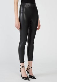 Czarne legginsy ze sztucznej skóry z wysokim stanem, dopasowanym krojem i zamkami przy kostkach, zestawione z pasującymi czarnymi szpilkami z ostrym noskiem.