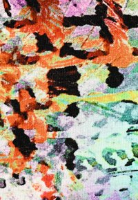 Colorful knit fabric featuring abstract patterns in orange, black, purple, and green with a textured surface and varying color intensity.