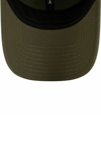Gorra de béisbol verde oliva con visera negra, hecha de una tela texturizada, con patrones de costura visibles y una forma estructurada.