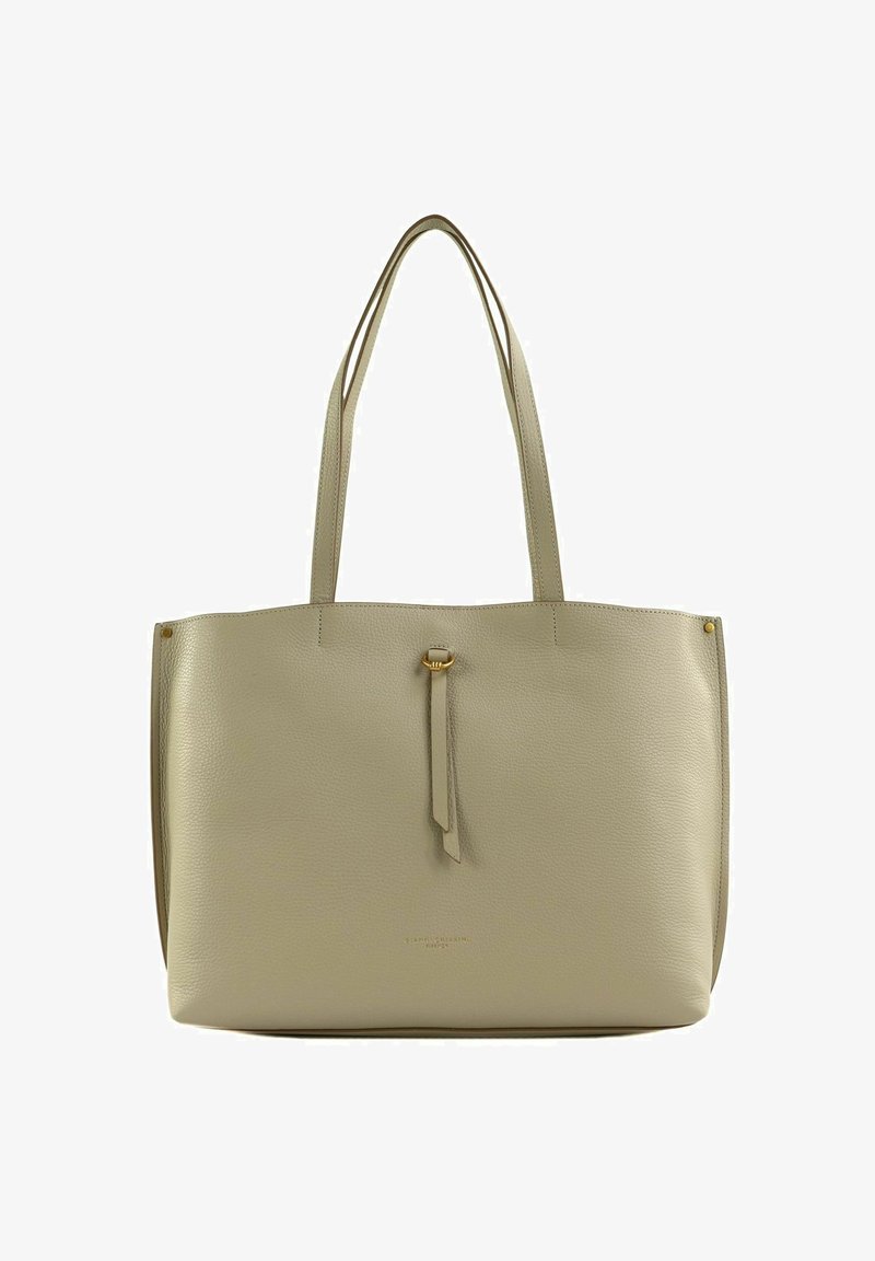 Sac fourre-tout en cuir beige clair avec doubles anses, surface texturée, détail de pampille central et design minimaliste. Pas de quincaillerie visible.
