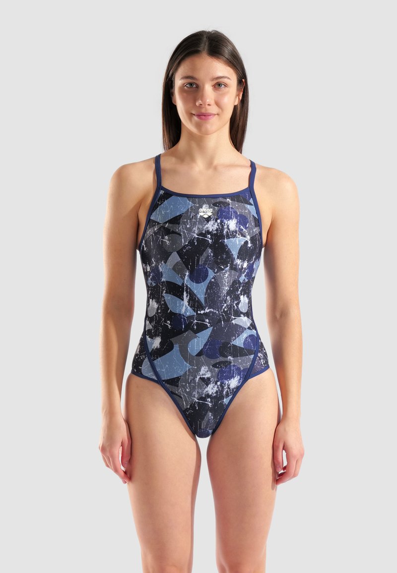 Maillot de bain une pièce en marine et bleu avec des motifs abstraits. Fabriqué en tissu lisse et extensible, avec des bretelles fines et ajustables et un décolleté en forme de scoop.