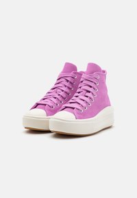 High-top sneakers in light pink suede. Features white rubber toe cap, platform sole, and metal eyelets with flat laces.
