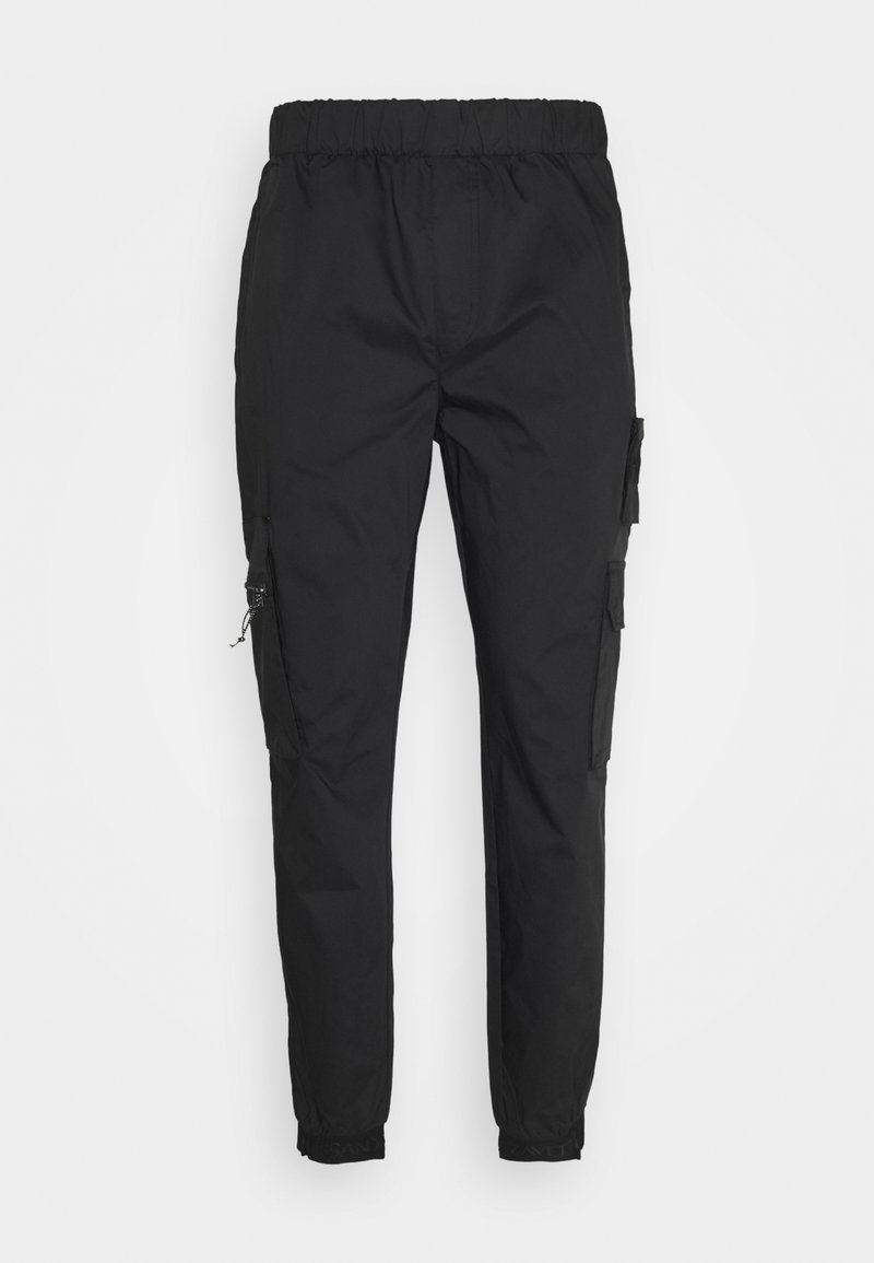 Pantalon cargo noir avec ceinture élastique et poignets, comportant une fermeture éclair latérale et des poches à rabat sur les deux jambes.