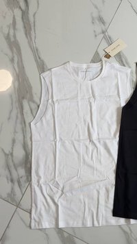 Weißes ärmelloses Baumwolloberteil mit rundem Ausschnitt, flach ausgelegt neben einem schwarzen ärmellosen Oberteil. Glatte Textur, minimale Falten.