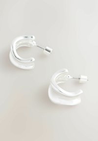 Sudraba metāla stīpu auskari ar vijīgu dizainu, ar pulētu virsmu un drošu aizdares stiprinājumu.