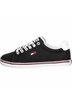 Czarny niski sneaker z białą podeszwą, białym i czerwonym paskiem, białymi sznurowadłami z tekstem oraz małym logo flagi w kolorach czerwonym, białym i niebieskim na boku.
