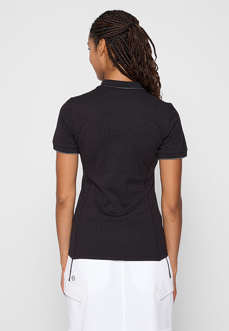 Polo noir avec un motif zèbre texturé, à manches courtes et col, avec un bord blanc contrastant sur les bords.