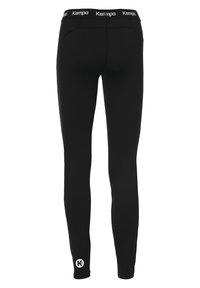 Leggings neri realizzati in tessuto elasticizzato con una fascia alta in vita e il marchio "Kempa". Texture liscia, design aderente e dettaglio del logo sulla caviglia sinistra.
