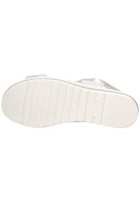 White rubber shoe sole with horizontal ridges and a smooth rounded toe. Features molded branding and a layered design for grip.