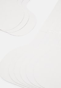 Découpes en papier blanc de différentes formes arrondies, empilées soigneusement. Surface texturée avec des bords nets, finition lisse et sans motifs visibles.