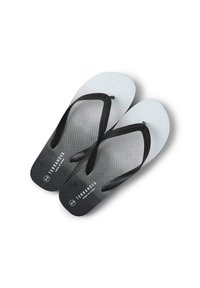 Infradito bianco e nero con superficie testurizzata, cinturini a contrasto e un motivo a gradiente che va dal grigio chiaro al grigio scuro.