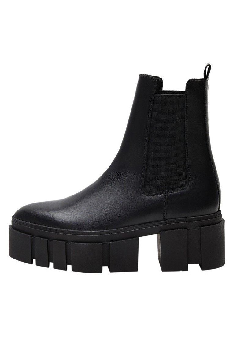 Zwarte leren enkelboots met elastische zijkanten, stevige platformzolen en een gladde afwerking. Voorzien van een lus aan de achterkant voor gemakkelijk aantrekken.