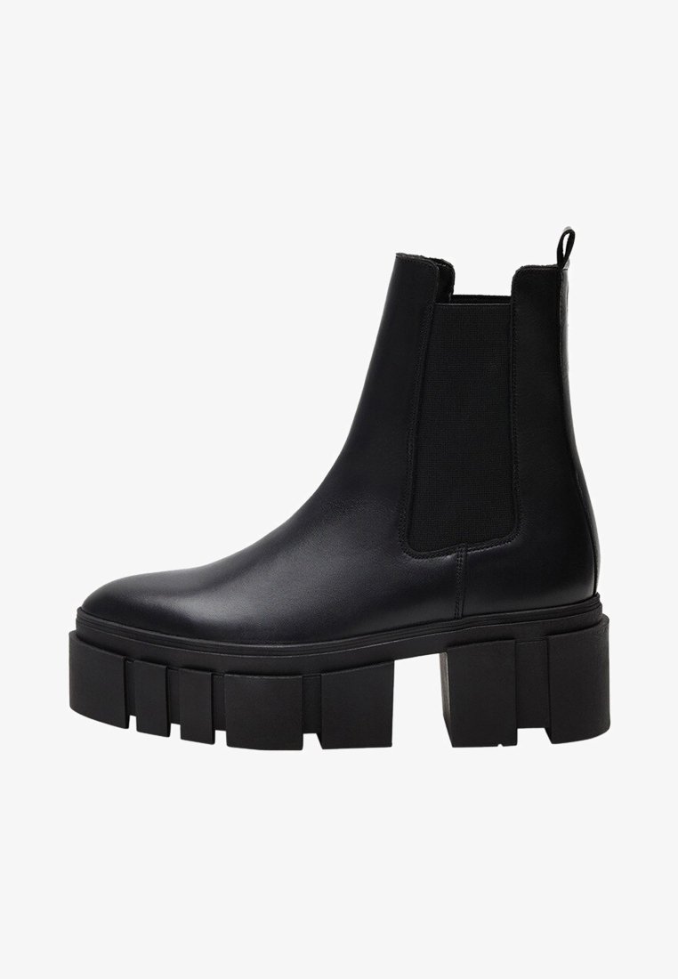 Zwarte leren enkelboots met elastische zijkanten, stevige platformzolen en een gladde afwerking. Voorzien van een lus aan de achterkant voor gemakkelijk aantrekken.