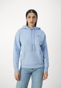 Felpa azzurra con cappuccio, tasca a marsupio, cappuccio con cordino e piccolo logo rosso sul lato sinistro del petto. Tessuto morbido, vestibilità rilassata.