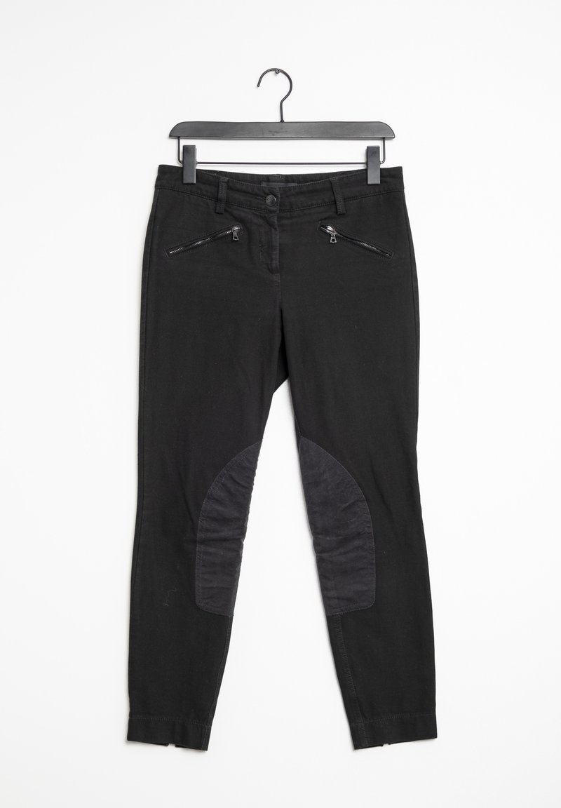 Pantalon noir slim avec poches zippées à l'avant et renforts aux genoux, suspendu sur un cintre noir contre un fond blanc.