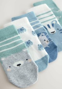 Quattro paia di calzini per bambini con motivi di orsi e animali, in tonalità di blu, teal e bianco, con diverse righe e trame.