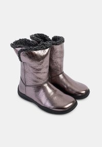 Botas de tobillo metálicas moradas con un forro de piel sintética negra texturizada y suela de goma negra flexible. Superficie lisa con acentos cosidos.