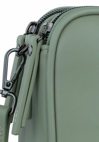 Borsa in pelle verde con texture liscia, accessori in argento, doppi zip e gancio removibile. Design compatto e rettangolare.