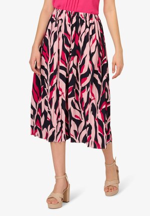 Midikleid aus leichtem Stoff mit einem Muster aus pinken, marineblauen und schwarzen Blättern, mit einem elastischen Bund. Kombination mit beigen Blockabsätzen.