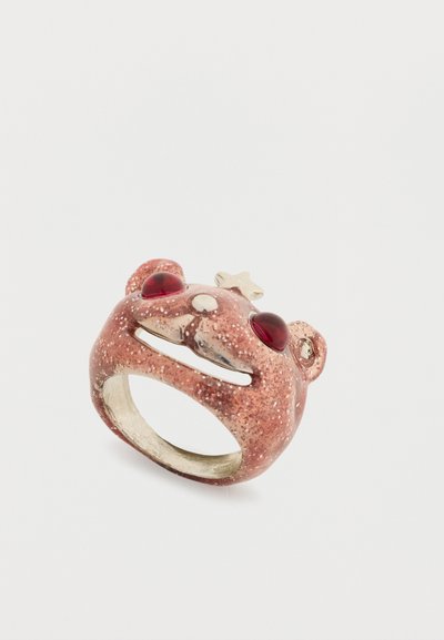 Bear-shaped ring made from a glittery rose gold material, featuring red gemstone eyes and a small star accent on the top.