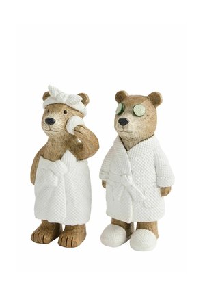 To bamsefigurer i hvide spa-kåber; den ene har håndklædeindpakning og ansigtssvamp, den anden har tøfler og agurkøjenpads.