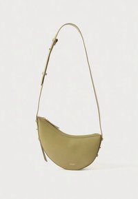 Zaļas ādas plecu soma ar pusmēness formu, aprīkota ar rāvējslēdzēja aizdari un vienu regulējamu siksnu, minimālistisks dizains bez rakstiem.