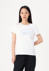 White cotton t-shirt with short sleeves, featuring blue text that reads "NOTHING LIKE THIS LOVELY SUMMER DAY" in an arc shape.