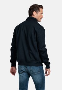 Zwarte sweatshirt met een hoge kraag, lange mouwen en een ontspannen pasvorm. Beschikt over ribbelboorden en een ribbel Tailleband, met een gladde textuur en minimale stiksels.