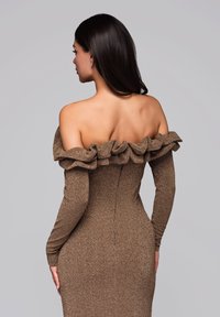Hnědress s odkrytými rameny, řaseným výstřihem, dlouhými rukávy, přiléhavým střihem a texturovanou látkou, viděný zezadu.