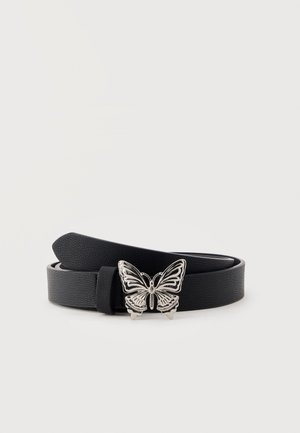 Ceinture en cuir noir texturé avec une boucle en forme de papillon argentée, enroulée sur un fond clair uni.