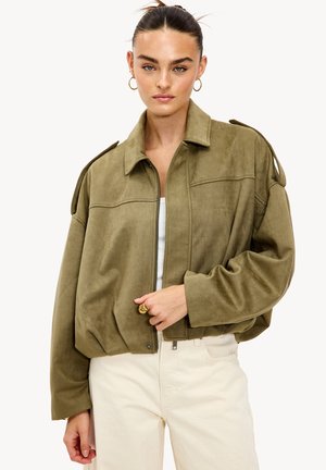 Veste courte en suédine vert olive avec une fermeture éclair à l'avant, un grand col et des détails aux épaules. Texture lisse avec des manches surdimensionnées.