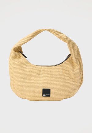 Bolso de hombro de tela beige tejida con una asa curva y una cremallera negra, con una pequeña etiqueta negra en la parte frontal.