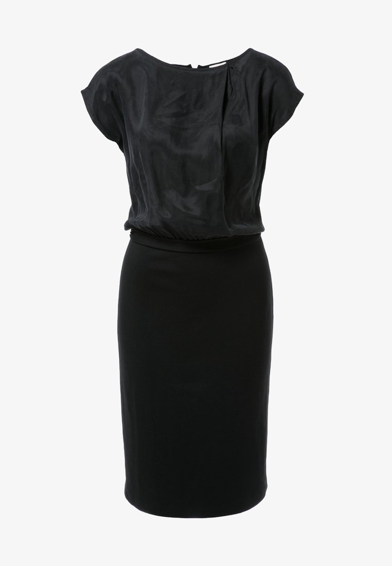 Robe noire longueur genou avec un haut en soie ample à manches courtes et une jupe crayon ajustée en bas.