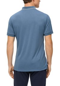 Koszulka polo w jasnoniebieskim kolorze, z krótkimi rękawami, prostym kroju z bocznymi rozcięciami, z dzianym kołnierzykiem i subtelnym kontrastowym wykończeniem wokół szyi.