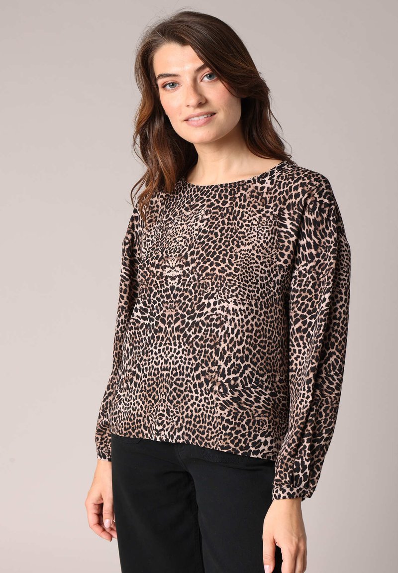 Blouse à manches longues imprimée léopard avec un col rond, des manches froncées et une texture lisse et douce dans des tons de marron et de noir.