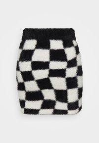 Mini-jupe en fausse fourrure avec un motif en damier noir et blanc. Textile doux avec une taille haute et une texture lisse.