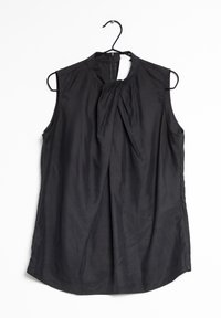 Černý top bez rukávů vyrobený z hladkého materiálu, vybavený uzlovým detailem v přední části, vysokým výstřihem a zadním zipem pro zapínání.