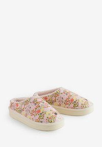 Een paar roze instapslippers met een bloemen- en geometrisch patroon en een fluffy voering, tegen een witte achtergrond.