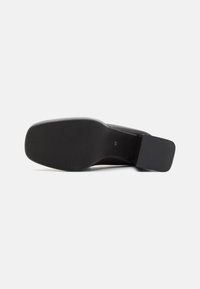 Black high-heel shoe sole, featuring a smooth surface, slightly pointed toe, wide rectangular heel, and embossed size number 37.
