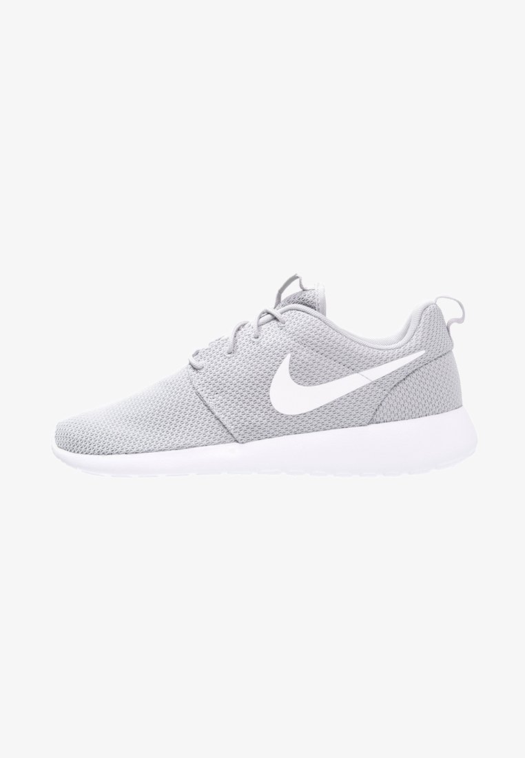 Harmaa verkkomallinen urheilukenkä, jossa on valkoinen kumipohja ja nauhat. Sivulla on näkyvä valkoinen Nike-logo ja pyöristetty kärki.