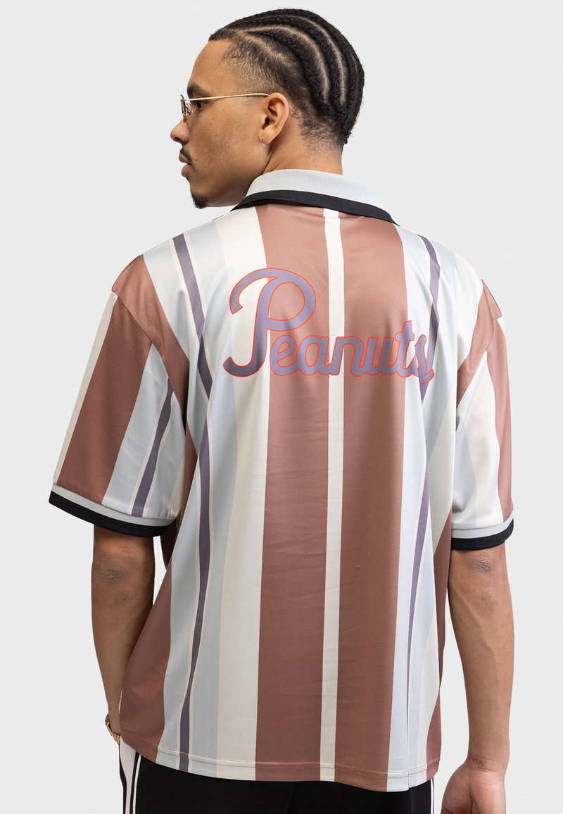 Short-sleeve shirt featuring vertical stripes in brown, cream, and gray. Back displays the word "Peanuts" in red cursive. Black collar and cuffs.