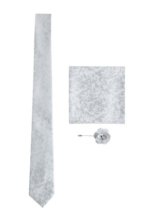 Weiße Seidenkrawatte, passendes florales Einstecktuch und Stoff-Rosen-Reversnadel auf weißem Hintergrund arrangiert.