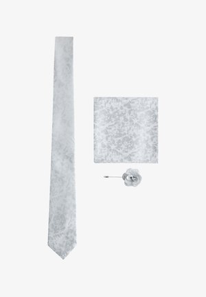 Weiße Seidenkrawatte, passendes florales Einstecktuch und Stoff-Rosen-Reversnadel auf weißem Hintergrund arrangiert.