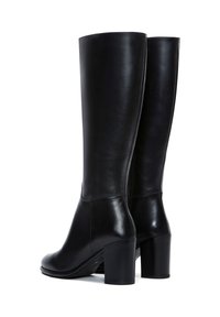 Botas de cuero negro hasta la rodilla con un acabado suave, que presentan un tacón cuadrado y costuras mínimas, mostrando un diseño elegante y moderno.