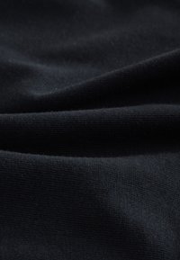 Fekete, sima textúrájú szövet, finom redőkkel és gyűrődésekkel, egységes színnel minták vagy díszítések nélkül.